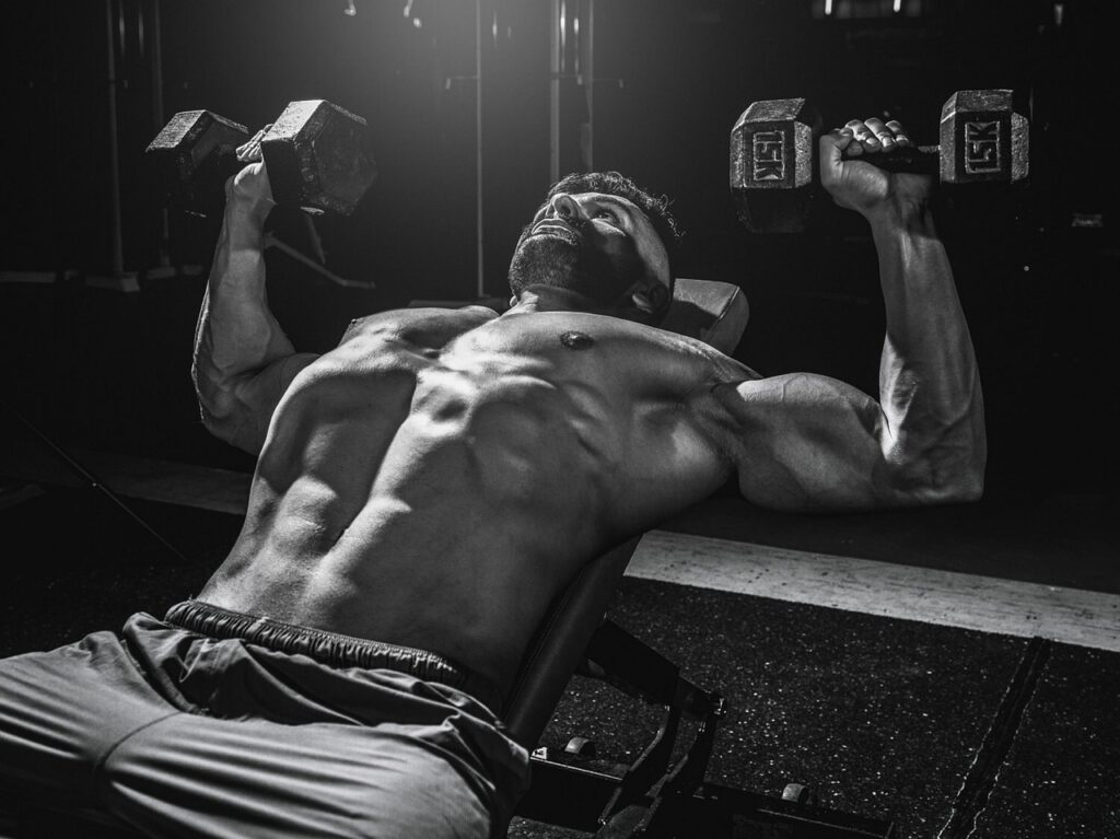 Jeune homme exécutant un exercice de musculation pour les deltoïdes, épaules, au développé militaire.