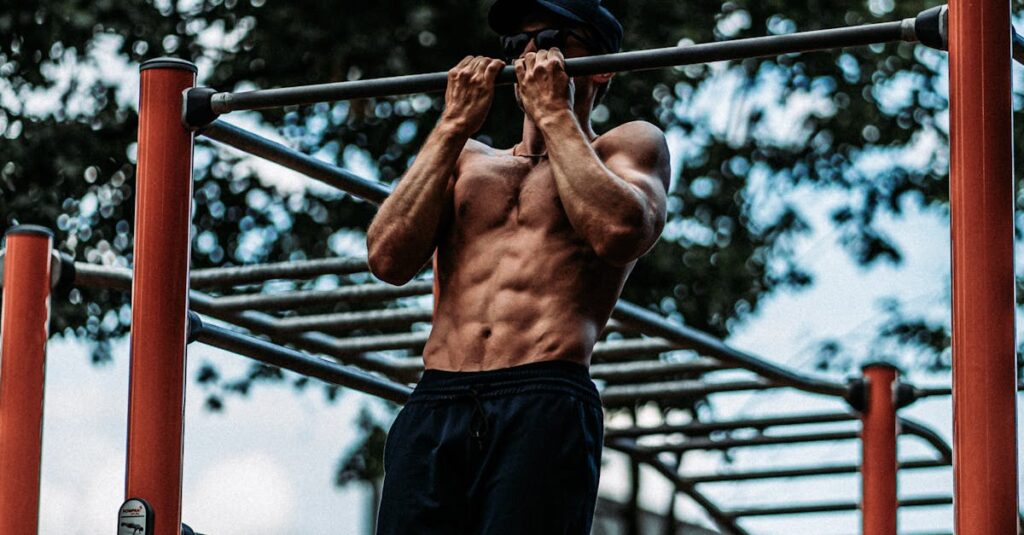 Athletic man performing pull-ups on a bar outdoors, showcasing fitness and strength.
