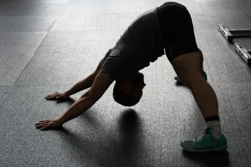 pexels-photo-209887-209887 Silhouette of a man stretching indoors, showcasing fitness and flexibility.