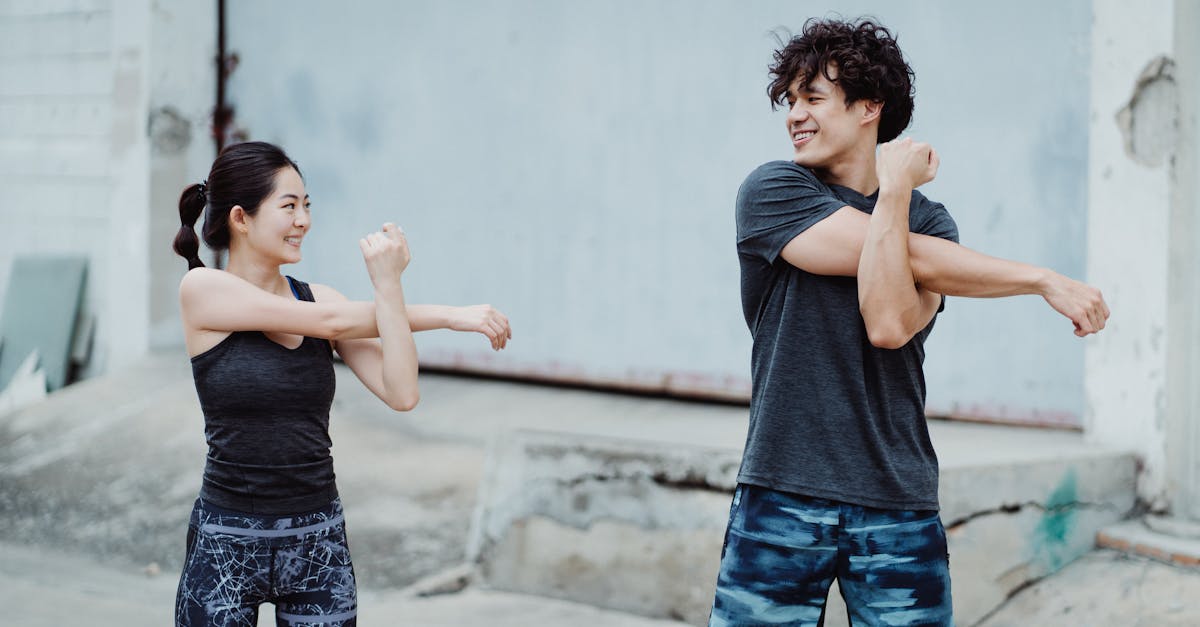 Couple engaging in a warm-up stretch outdoors. Emphasizes health and fitness.
