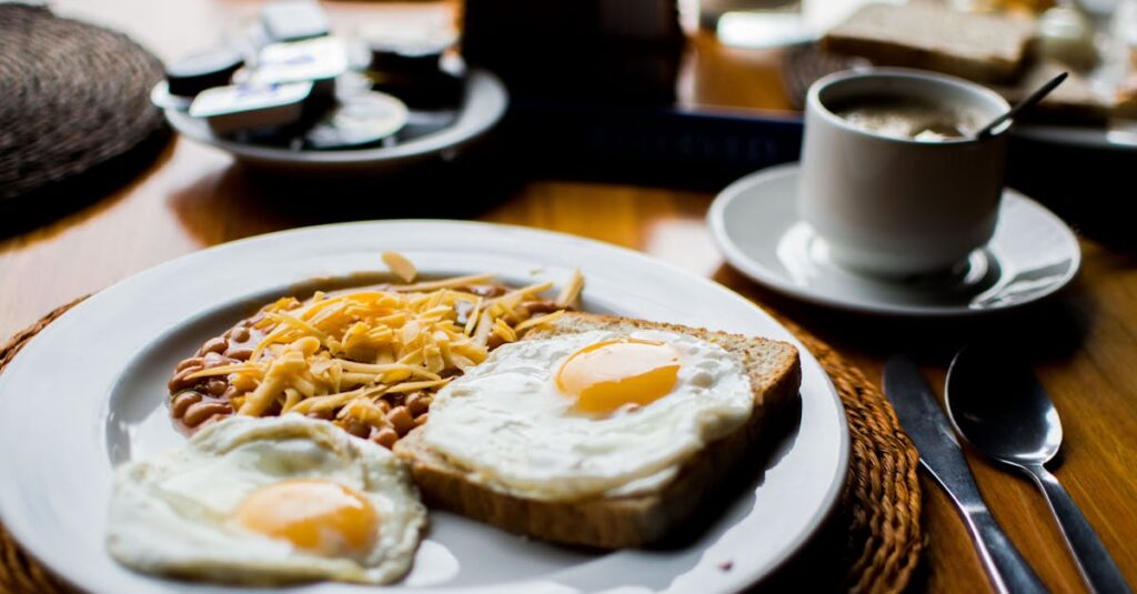 A hearty breakfast with fried eggs, baked beans, and toast served with coffee in a cozy setting.