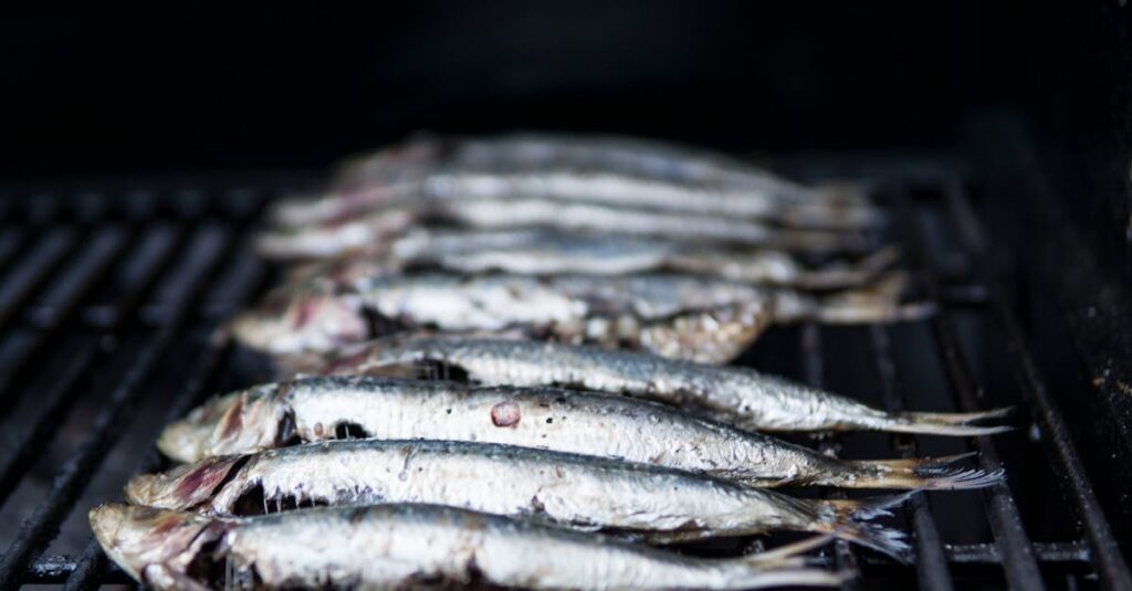 Close-up of sardines being grilled, perfect for healthy seafood cuisine.