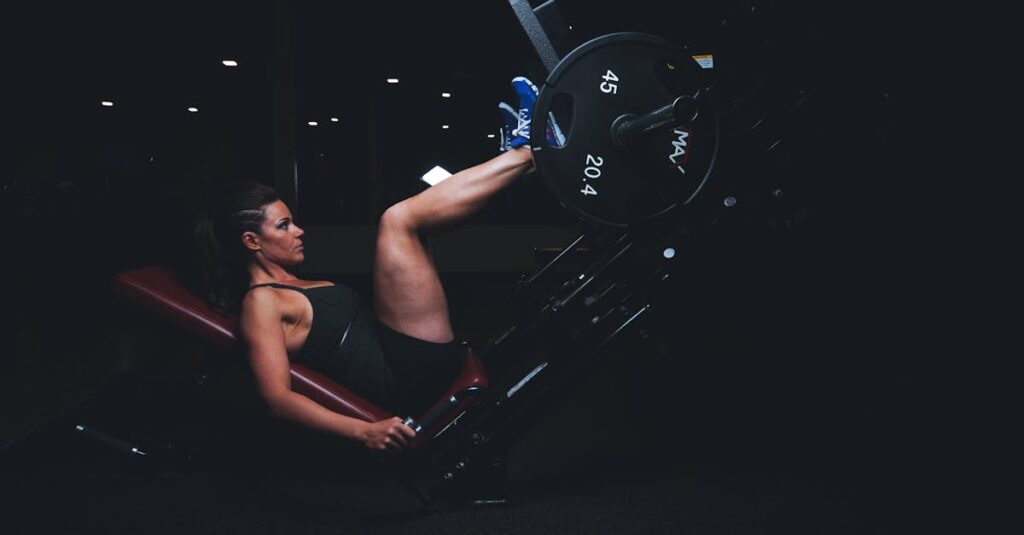 A woman engages in an intense leg press workout at the gym, showcasing strength and fitness.