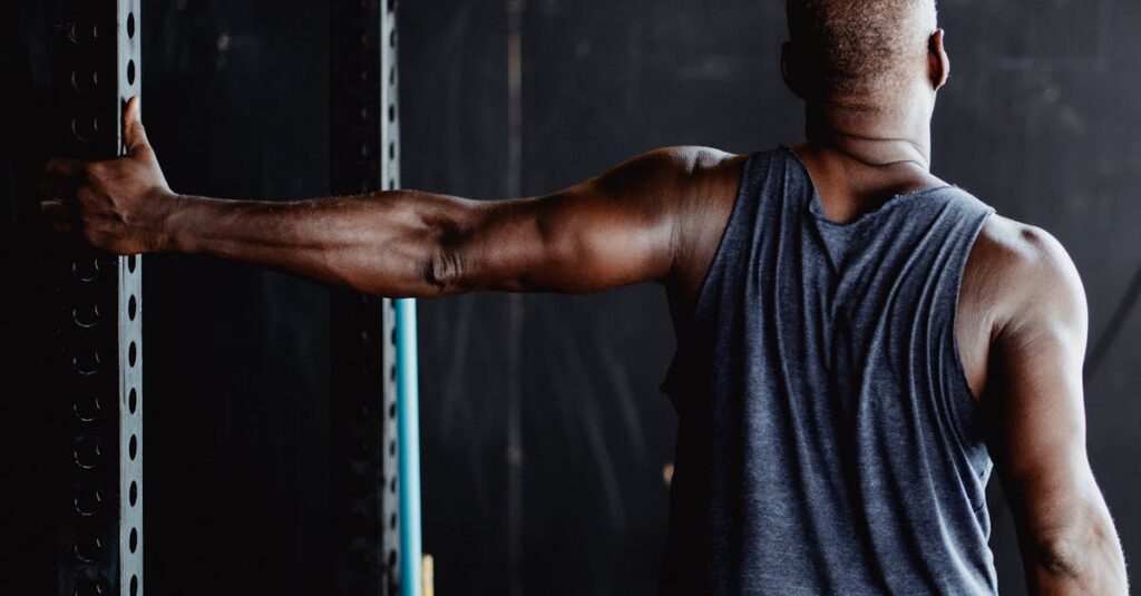 An athletic man stretching his arm in a gym, showcasing strength and flexibility.