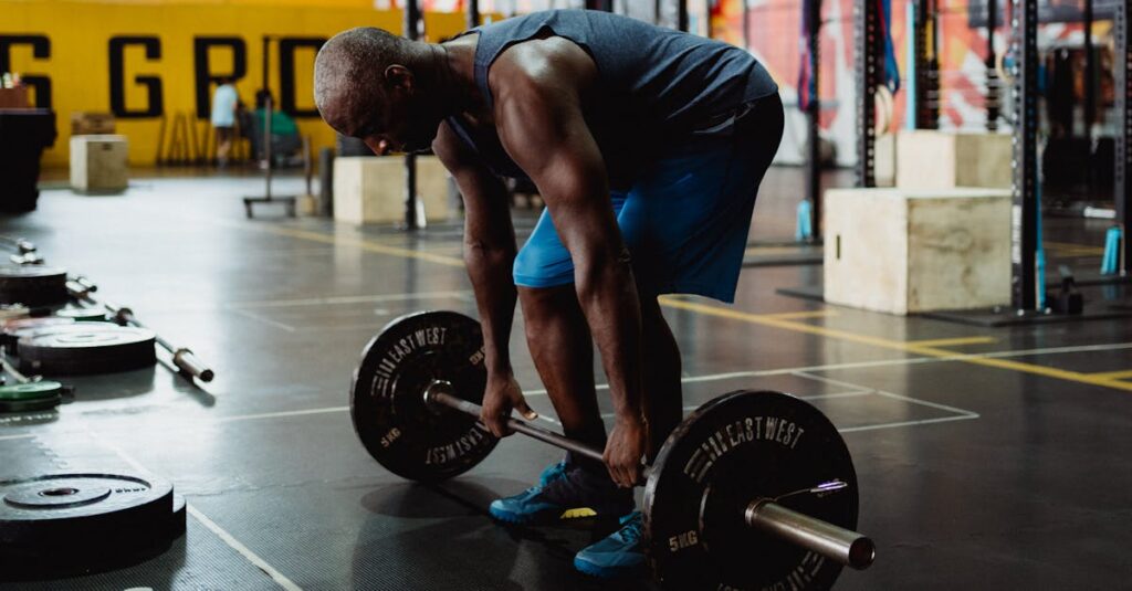 Athletic man practicing deadlifts in an industrial-style gym for strength training.