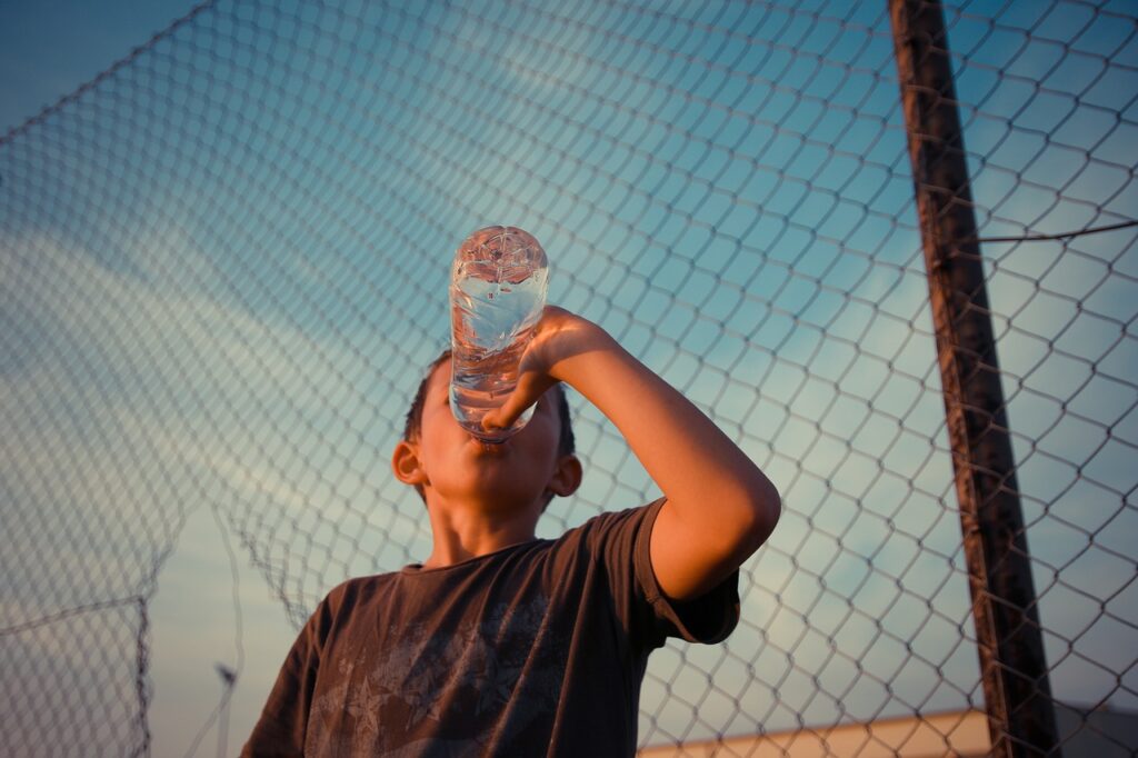 Jeune homme buvant de l'eau, hydratation, sport.