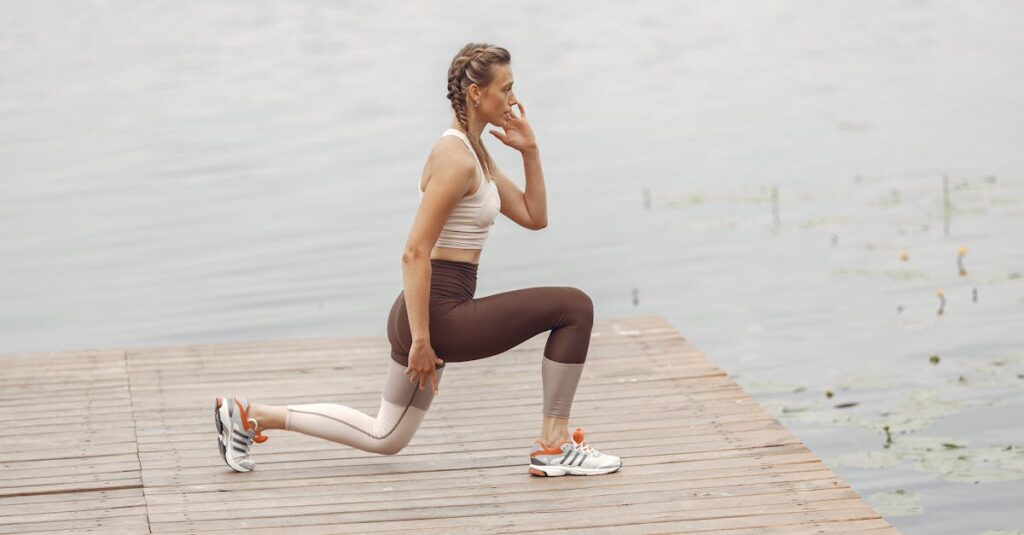 A woman performs lunges on a lakeside wooden deck, showcasing a fit lifestyle outdoors.
