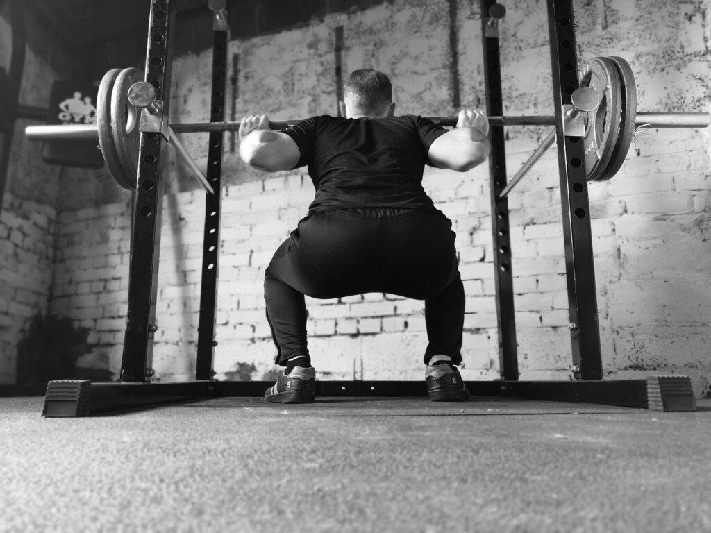 Jeune homme pratiquant de la musculation en salle de sport, programme de musculation.