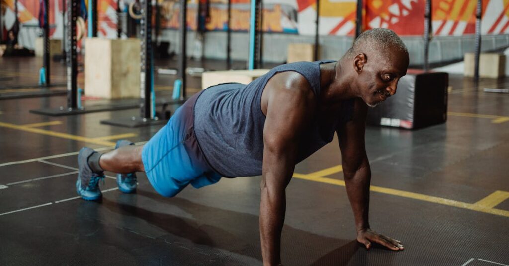 Homme pratiquant des pompes au sol dans une salle de sport.