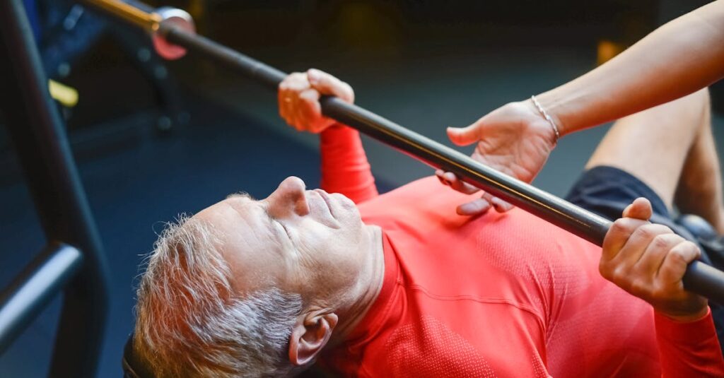 Un homme âgé effectuant un exercice de développé incliné à la barre en salle de sport.