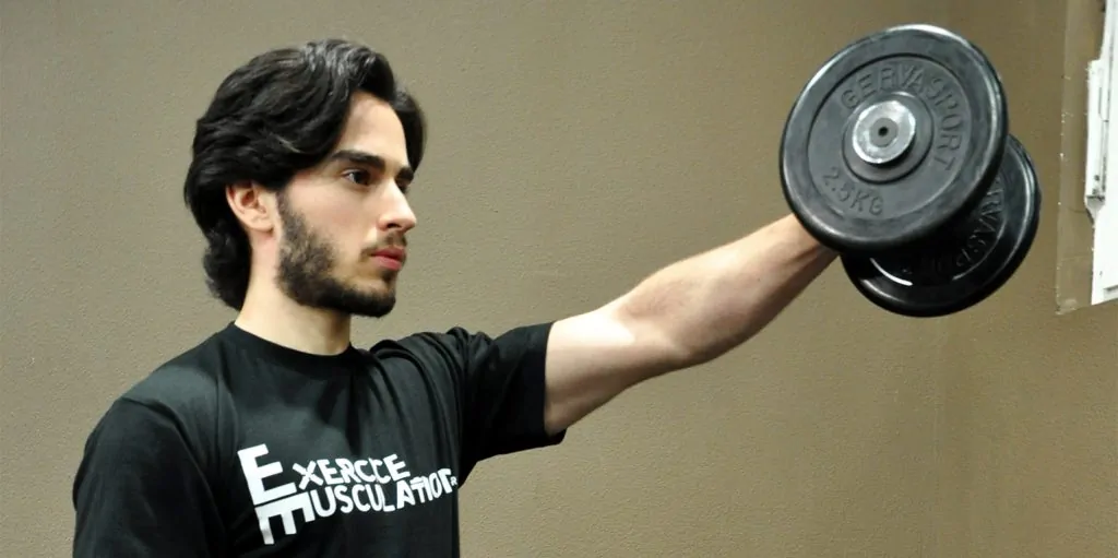 Jeune homme effectuant des élévations frontales aux haltères.